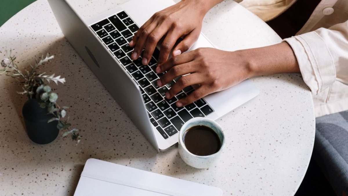 person writing blog laptop coffee
